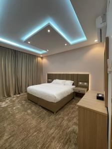 a bedroom with a bed and a blue light on the ceiling at قمم بارك 3 Qimam Park Hotel in Abha