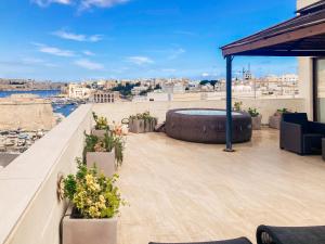 a rooftop patio with a hot tub on a building at Valletta and Grand Harbour Lookout in Kalkara