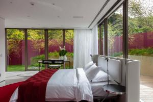 a bedroom with a bed and a large window at Unique Garden in Mairiporã