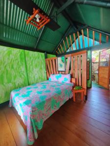 ein Schlafzimmer mit einem Bett in einem grünen Zimmer in der Unterkunft Finca La Puesta del Sol - Miramar de Sierpe in Sierpe