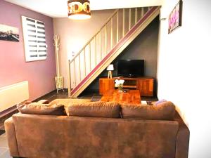 Una sala de estar con un sofá y una escalera. en Villa marine, en Hirel