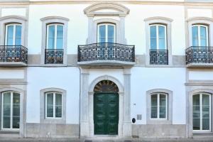 een gevel van een wit gebouw met een groene deur bij Dolce Faro Niente Apartment in Faro