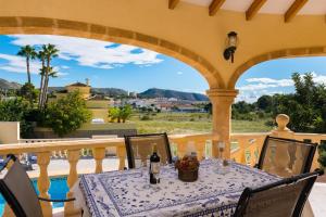 a table and chairs on a balcony with a view at Villa Llobell - Plusholidays in Moraira