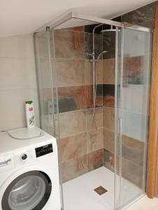 a shower stall with a washing machine in a bathroom at Mirador Porta da Vila, Noia in Noya