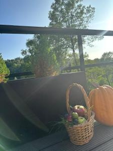 a basket of fruit and a pumpkin on a porch at Forest House Doftana in Teşila