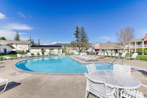 a swimming pool with white chairs and a table at Silverado Resort and Spa 381 in Napa