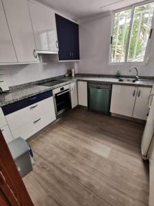 オリーバにあるCaseta en la playa de Olivaの白いキャビネットと木製の床を備えたキッチン