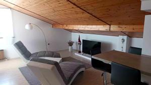 ein Wohnzimmer mit einem Tisch, Stühlen und einem Kamin in der Unterkunft Apartmaji Ri-100 in Portorož