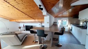 a kitchen and living room with a wooden ceiling at Apartmaji Ri-100 in Portorož