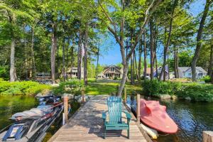 - un quai avec 2 chaises et des bateaux sur une rivière dans l'établissement Yellow Door Cottage, à Meredith