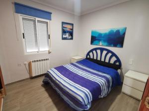 オリーバにあるCaseta en la playa de Olivaのベッドと窓のある小さな寝室