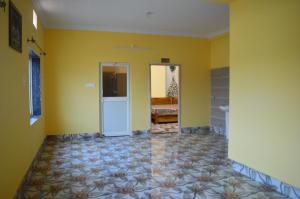 een lege kamer met gele muren en een deur bij TITILI PLAZA in Puri