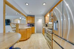 a kitchen with wooden cabinets and a wooden table at Pet-Friendly Dearborn Home Less Than 2 Mi to Downtown! in Dearborn