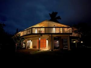 a house with a deck on top of it at night at Newly listed luxury home - great location + views in Princeville