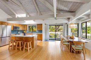 a kitchen with a table and chairs and a kitchen with a counter at Newly listed luxury home - great location + views in Princeville
