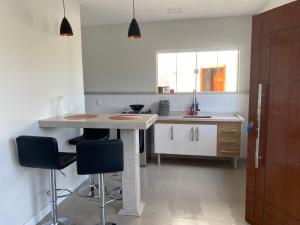 a kitchen with a counter and some chairs in it at EuroPark Chalés centro in Domingos Martins