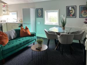 a living room with a green couch and a table at Cottage styled 2 Bedroom City Apartment Birmingham - Free Parking, no Caz in Birmingham