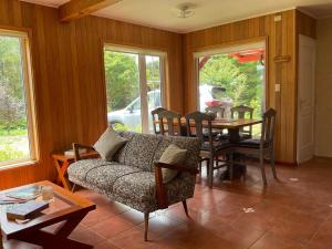 uma sala de estar com uma mesa e um sofá em Casa Viña em Valdivia