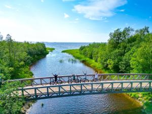 a group of people riding bikes on a bridge over a river at Nallikari Holiday Village - Aalto Seaside Apartments in Oulu