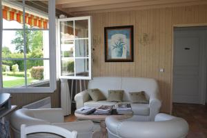 a living room with a couch and chairs and a table at Domaine de La Méniguère in Saint-Gein