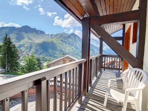 a porch with a chair and a view of mountains at Duplex spacieux aux pieds des pistes avec parking et balcon - FR-1-344-732 in Saint-Martin-de-Belleville