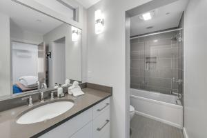 a bathroom with a sink and a toilet and a shower at Downtown Delight in Jackson +48 photos