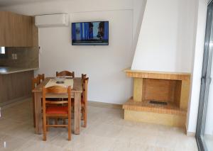 a kitchen with a table and a fireplace at ALTAVILLAS Apartment 6 KYRA in Kakí Vígla
