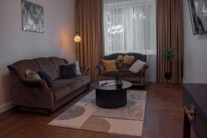 una sala de estar con un sofá y una mesa en Historical City Center Apartment Zalgiris Arena, en Kaunas