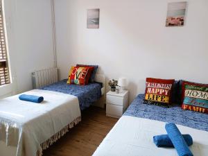sypialnia z 2 łóżkami z niebieską pościelą i poduszką w obiekcie Private rooms in Born w Barcelonie