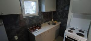 a small kitchen with a sink and a window at Apartmani Stojković Kuršumlija in Kuršumlija