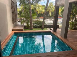 una piscina junto a una casa con terraza en Luxury villa en Tamarin