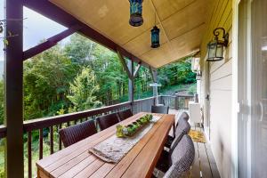 a wooden table on a deck with chairs at Villa Zara Mountain Retreat in Banner Elk