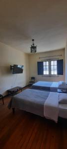 a bedroom with two beds and a flat screen tv at Peter's Hostel in Arequipa