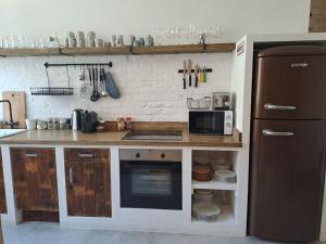 a kitchen with a counter with a refrigerator and a microwave at Parpar 19 Apartman - Cosy flat in the center in Budapest