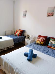 sypialnia z 2 łóżkami i niebieskim ręcznikiem w obiekcie Private rooms in Born w Barcelonie