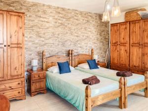 - une chambre avec 2 lits et un mur en briques dans l'établissement XL Bugibba Home, à San Pawl il-Baħar