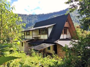 a house with a black roof in the forest at Sacha Urco Lodge -Private Cloud Forest Reserve in Mindo- Lugar remoto- 4x4 recommended in Mindo