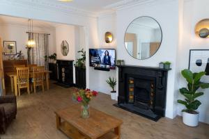 a living room with a fireplace and a mirror at Large Home Sleeps 6 Central Location Free Parking in Plymouth