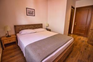 sypialnia z dużym łóżkiem i drewnianą podłogą w obiekcie 4 Rooms Gjirokastra w Gjirokastrze