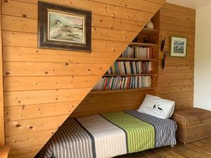 1 dormitorio con 1 cama en una pared de madera en Lumière et verdure, maison de campagne, en Miniac-Morvan