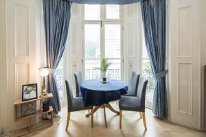 a dining room with a blue table and chairs at Cosy High-ceiling Victorian flat with balcony - 2mins to Hyde Park, Kensington Palace, NottingHill, High Street Kensington,2BR 2Baths in London