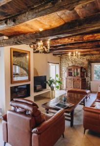 Porri的住宿－A Macina，客厅配有皮革家具和木制天花板