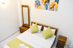 a white couch with two yellow pillows in a room at TwinsTop Villa in Minuwangoda
