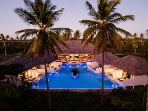 a resort with a pool and palm trees at night at MKNI Hotel - Ikaika Makani Experience in Prea