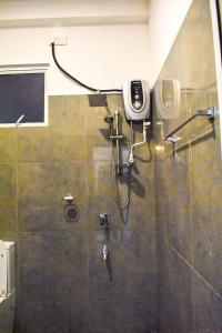 a bathroom with a shower with a camera on the wall at TwinsTop Villa in Minuwangoda
