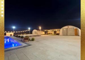 a large parking lot with a pool at night at Desert Breeze Cocoon in Ras al Khaimah