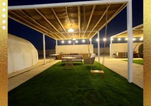 a tent with a table and chairs on a lawn at Desert Breeze Cocoon in Ras al Khaimah