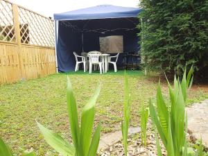 a blue tent with a table and chairs in a yard at Maison centre-ville calme avec jardin in Lons-le-Saunier