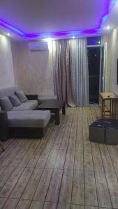 ein Wohnzimmer mit Sofa und lila Beleuchtung in der Unterkunft Кобаладзе 2 in Batumi