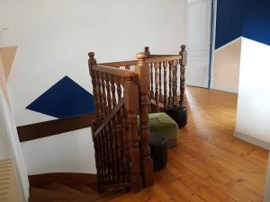 a spiral staircase with a green ottoman in a hallway at Maison centre-ville calme avec jardin in Lons-le-Saunier